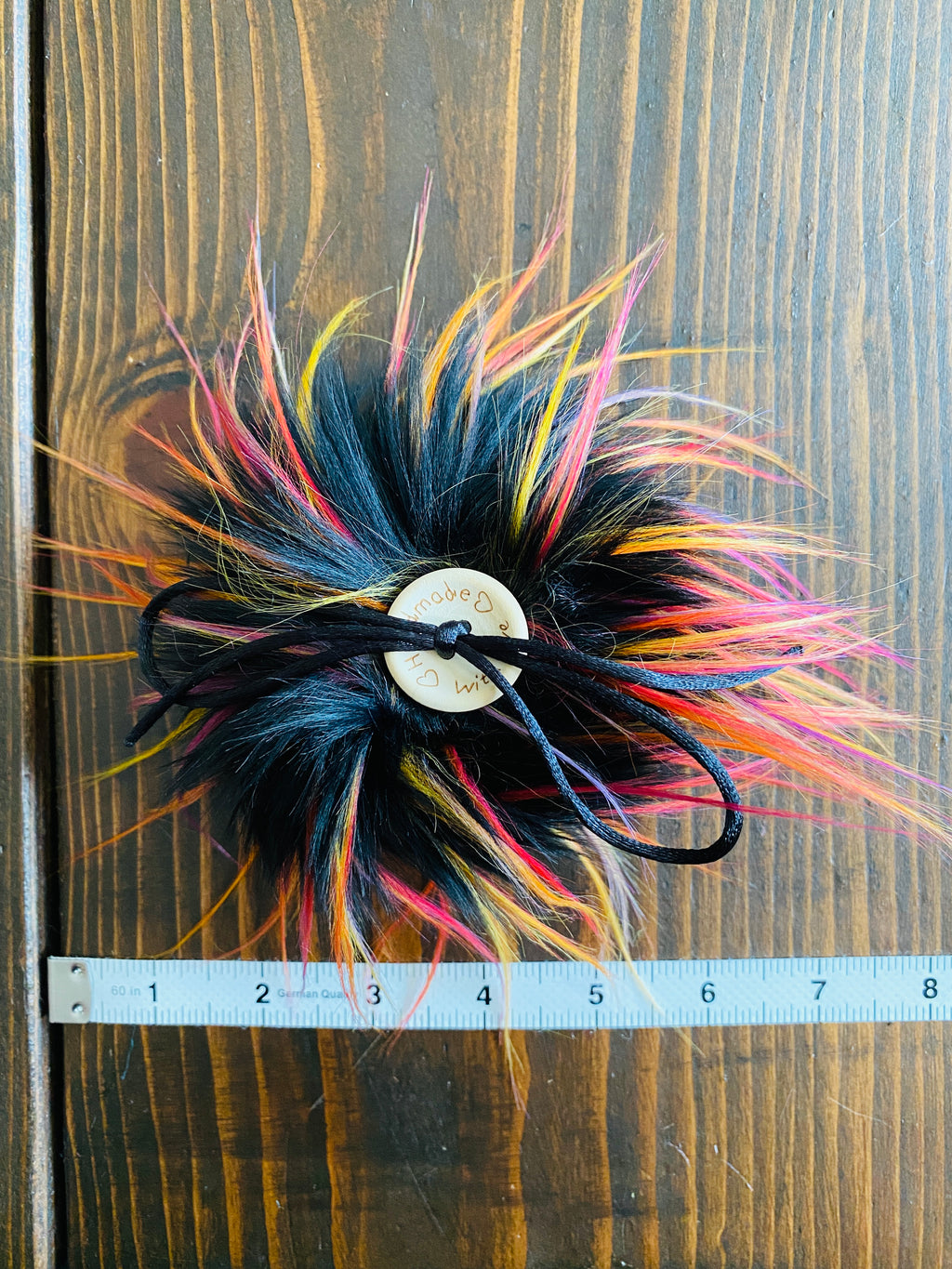 MADE TO ORDER Fun and funky black with long tips of yellow, red, pink, orange and purple faux fur pom pom with wooden button